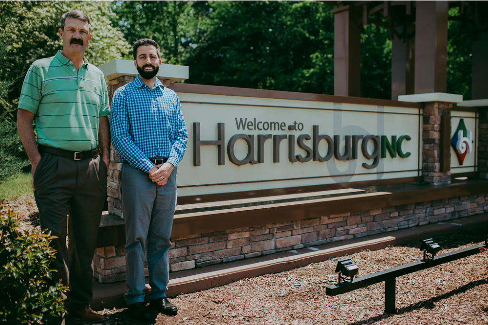 Drs Icard & Strein standing in front of Harrisburg NC sign